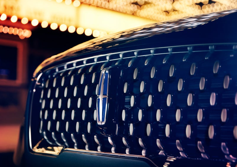 The Corsair Grand Touring grille shows floating chrome ovals that catch the glowing light of a theater marquee and frame the distinctive Lincoln Star | Northgate Lincoln in Port Huron MI