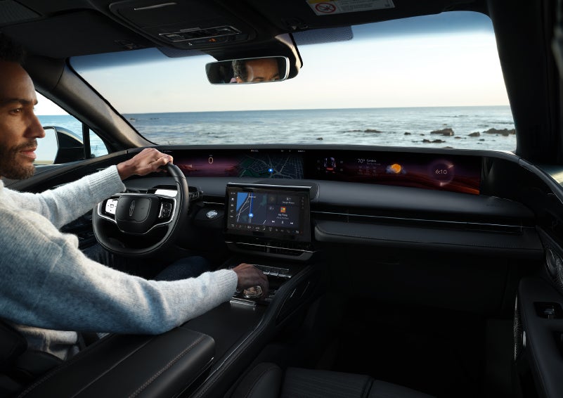 A driver of a parked 2024 Lincoln Nautilus® SUV takes a relaxing moment at a seaside overlook while inside his Nautilus. | Northgate Lincoln in Port Huron MI