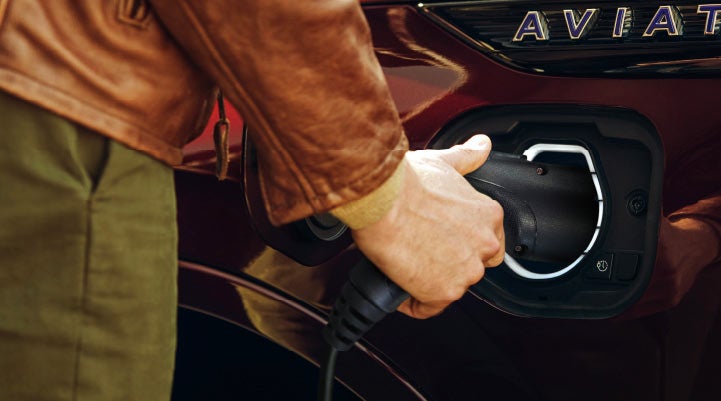 A hand is shown plugging in the charger into the charging port of a 2021 Lincoln Aviator | Northgate Lincoln in Port Huron MI