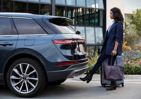 A woman with luggage and a bag opens the available hands-free liftgate by kicking her foot under the bumper | Northgate Lincoln in Port Huron MI
