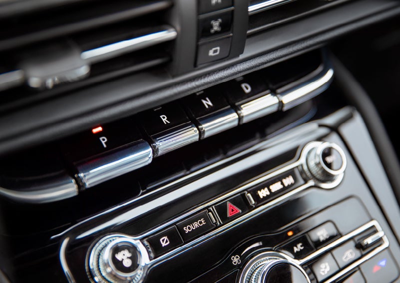 The Park button on the elegant Piano Key Shifter is lit up and engaged as light dances off the chrome accents and horizontal design lines | Northgate Lincoln in Port Huron MI