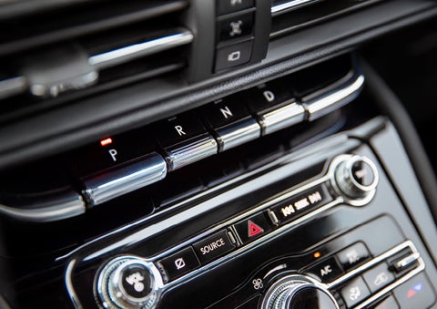 The Park button on the elegant Piano Key Shifter is lit up and engaged as light dances off the chrome accents and horizontal design lines | Northgate Lincoln in Port Huron MI