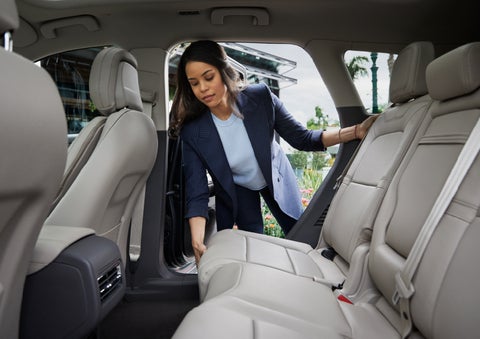A woman slides the second-row seat forward to create more cargo space | Northgate Lincoln in Port Huron MI