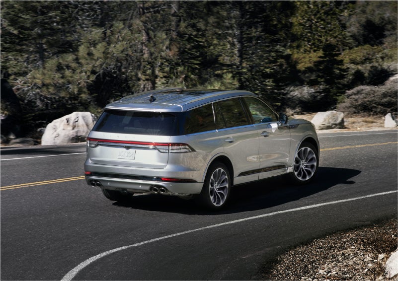 A 2023 Lincoln Aviator® Grand Touring model is shown being driven on a tight turn of a mountain road | Northgate Lincoln in Port Huron MI