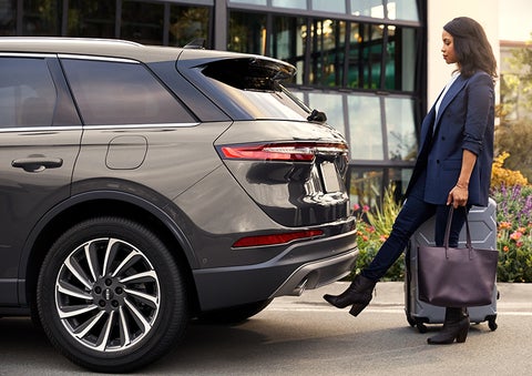 A woman with her hands full uses her foot to activate the available hands-free liftgate. | Northgate Lincoln in Port Huron MI