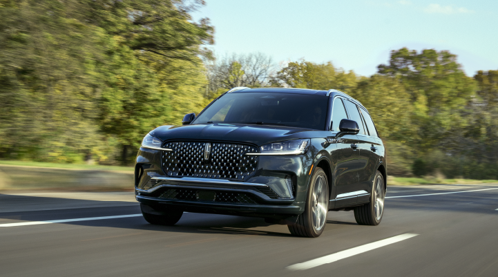 A 2025 Lincoln Black Label Aviator® SUV is being driven down a road lined with trees. | Northgate Lincoln in Port Huron MI