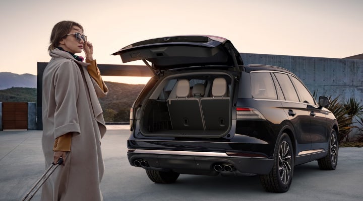 A woman approaches a 2026 Lincoln Aviator® SUV with its rear liftgate open. | Northgate Lincoln in Port Huron MI