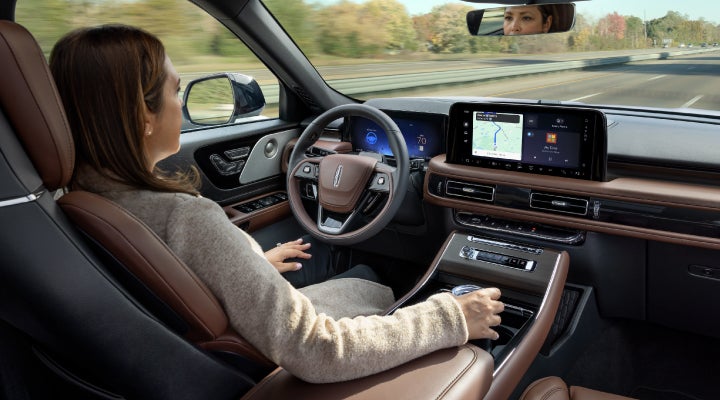 A 2026 Lincoln Aviator® SUV is being driven hands-free on a highway near a forest | Northgate Lincoln in Port Huron MI
