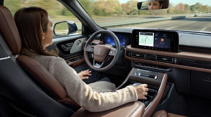 A 2027 Lincoln Aviator® SUV is being driven hands-free on a highway lined with trees. | Northgate Lincoln in Port Huron MI